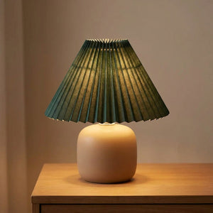Abat-jour plissé conique en tissu coloris Vert foncé sur une lampe allumée