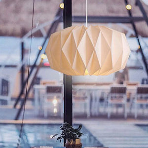 Abat-jour origami Globe éclairé en suspension sur une terrasse
