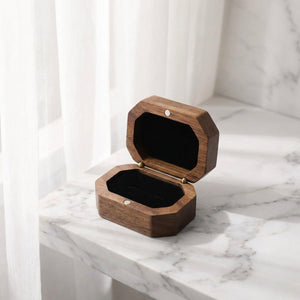 Boîte à bijoux en bois ouverte sur marbre blanc près d'un voilage lumière naturelle