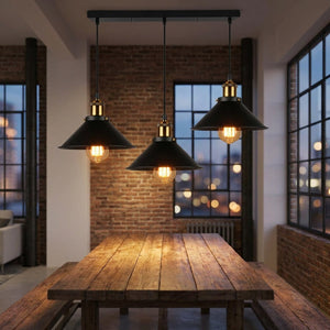 Triple suspension vintage industrielle à barre linéaire avec 3 abat-jour noirs au-dessus d'une salle à manger style loft