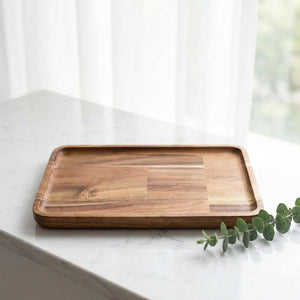 Plateau de service bois acacia sur surface marbre avec feuille d'eucalyptus