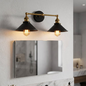 Applique murale double vintage industrielle avec deux abat-jour coniques noirs sur bras doré installée au-dessus d'un miroir de salle de bain