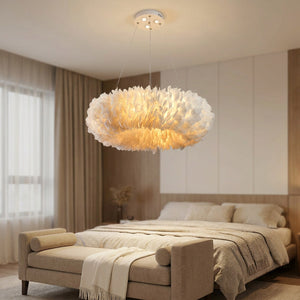 Lustre suspension en plumes blanches dans une chambre cocooning au-dessus d'un banc