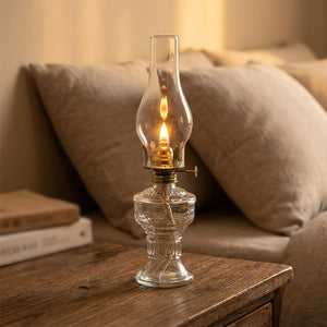 Lampe à pétrole vintage en verre transparent allumée sur table de chevet
