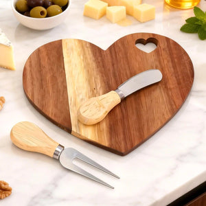Ensemble planche apéritif cœur en bois avec olives fromages et noix sur marbre