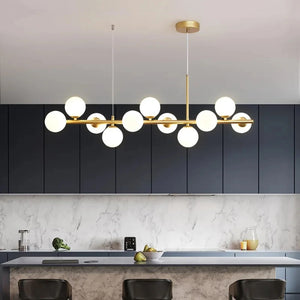 Lustre doré à globes de verre opalin suspendu au dessus d'un îlot de cuisine