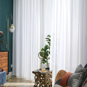 Voile blanc suspendu dans un salon moderne avec mur vert et plante