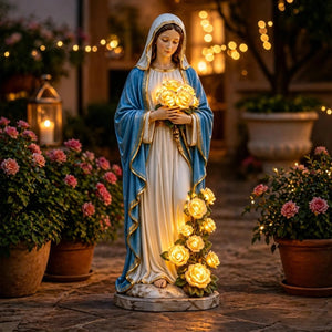 Statue de la Vierge Marie dans un jardin de nuit avec roses et lumières de guirlande en arrière-plan