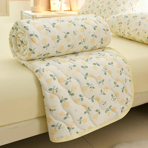 Couette matelassée à imprimé fleuri jaune roulée sur un lit