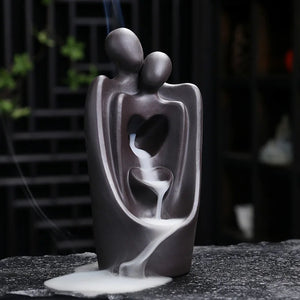 Brûleur d'encens couple enlacé avec fumée en cascade vue de face