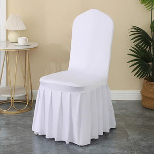 Housse de chaise blanche à jupe plissée installée dans un salon lumineux avec table d'appoint