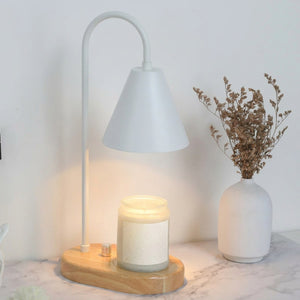 Chauffe-bougie électrique blanc allumé sur table en marbre avec vase de fleurs séchées