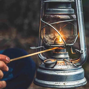 Détail de la flamme d'une lampe à pétrole allumée avec une allumette