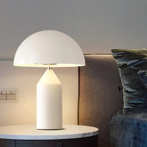 Lampe de table champignon blanche allumée sur une table de chevet en marbre à côté d'un canapé