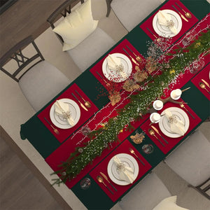 Table de Noël vue du dessus avec nappe vert chasseur sets de table rouges et centre de table garni