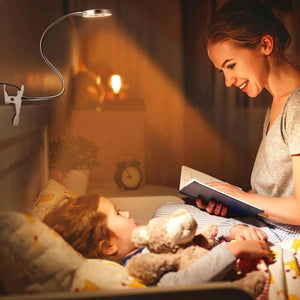Lampe pince fixée à une tête de lit éclairant une mère et son enfant en train de lire