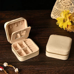 Boîte à bijoux en velours beige ouverte révélant les compartiments et le miroir