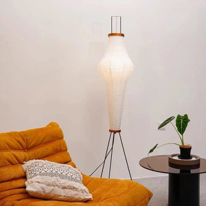 Lampadaire style Akari éclairant un salon moderne avec canapé velours ocre