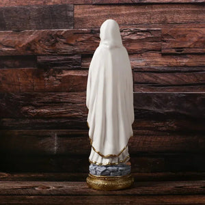 Statue de la Vierge Marie en résine vue de dos robe blanche avec liseré doré et voile socle doré fond bois