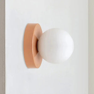 Applique murale terracotta avec globe en verre sur porte blanche