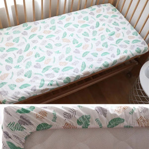 Vue rapprochée du drap housse bébé motif feuilles vertes sur un matelas de berceau