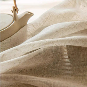 Gros plan sur la texture tissée du tulle façon lin près d'une théière en céramique