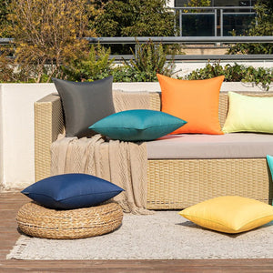 Housses de coussin extérieur colorées sur un canapé en rotin sur une terrasse en ville