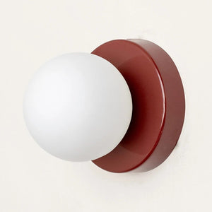 Applique murale grenat avec globe en verre sur mur clair