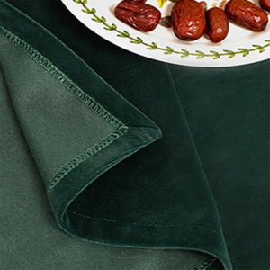 Détail du tissu vert chasseur de la nappe avec son ourlet cousu et sa texture douce