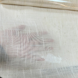 Main posée derrière le tulle transparent illustrant la finesse du tissu
