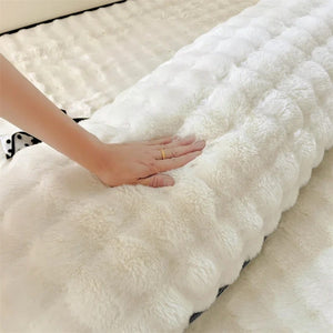 Gros plan sur la texture douce et pelucheuse du traversin blanc