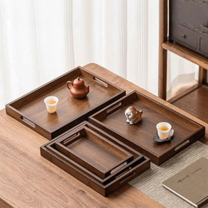 Cinq plateaux bambou noyer de différentes tailles présentés sur table en bois