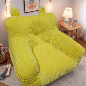 Pouf mini canapé enfant coloris jaune vif dans un salon avec lampe d'appoint