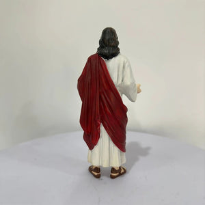 Statue de Jésus-Christ vue de dos drapé rouge sur robe blanche