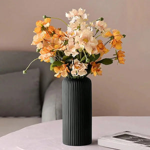 Vase noir à rainures avec fleurs séchées dans un salon