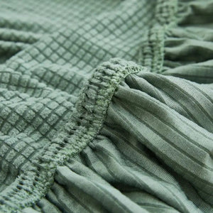 Gros plan sur le tissu jacquard texturé et la bande élastique de la housse de canapé