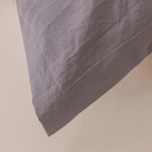 Détail de la bordure cousue de la taie de traversin gris