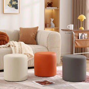Tabourets poufs ronds crème orange et gris disposés dans un salon lumineux