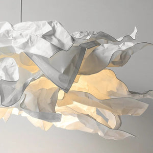 Gros plan sur les pétales de papier froissé et le voile organza du lustre nuage