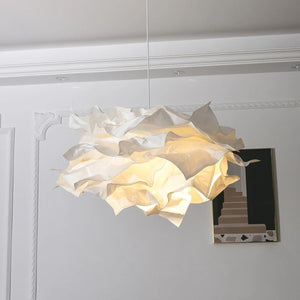 Lustre nuage en papier blanc allumé suspendu près d'un mur à moulures