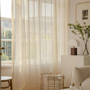 Voilage beige dans un salon lumineux avec panier en osier et coussin