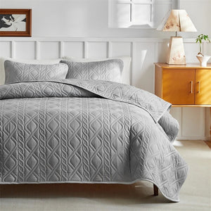 Vue complète du couvre-lit gris matelassé sur un lit