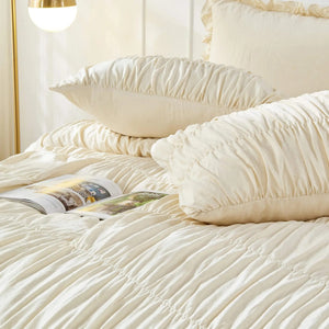 Parure de lit bohème chic sur un lit avec magazine déco et lampe dorée en chambre lumineuse