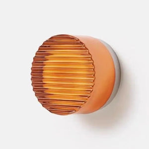 Applique murale LED ronde orange côtelée gros plan allumée