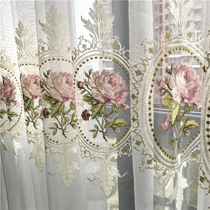Gros plan sur les pivoines roses brodées sur le tulle blanc translucide