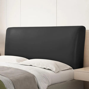 Housse de tête de lit noire posée sur un lit avec oreillers blancs