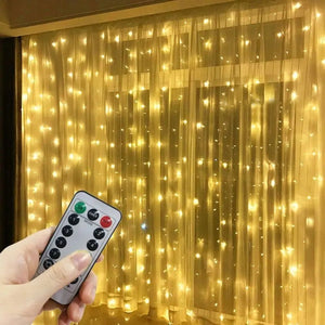 Rideau lumineux LED blanc chaud installé sur une fenêtre de chambre avec télécommande en main