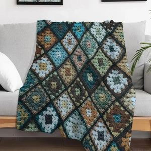 Plaid patchwork multicolore effet crochet drapé sur un canapé gris dans un salon avec plante verte