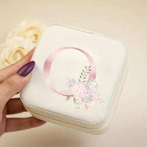 Boîte à bijoux initiale florale crème tenue en main - fond beige