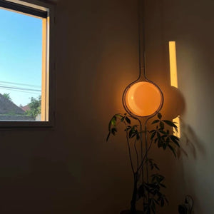 Lampadaire boule allumé au coucher du soleil près d'une fenêtre